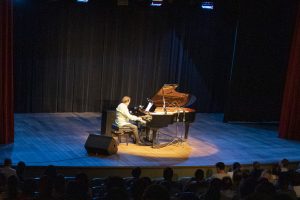 20190822 SARAH Centro Teatro Eduardo Lages 0G7A6883 No palco do Teatro SARAH Brasília, de terno azul e sentado ao piano, maestro e pianista Eduardo Lages acompanha a cantora Marina Elali, de pé e de vestido longo verde, em apresentação de grandes sucessos de Roberto Carlos e Erasmo Carlos.