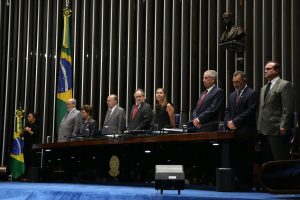Dra. Lúcia Willadino Braga em pé junto as outras autoridades durante a execução do hino nacional