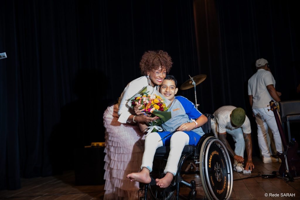 O paciente Guilherme Pontes Pereira entregando um buquê de flores a Isabel Fillardis.